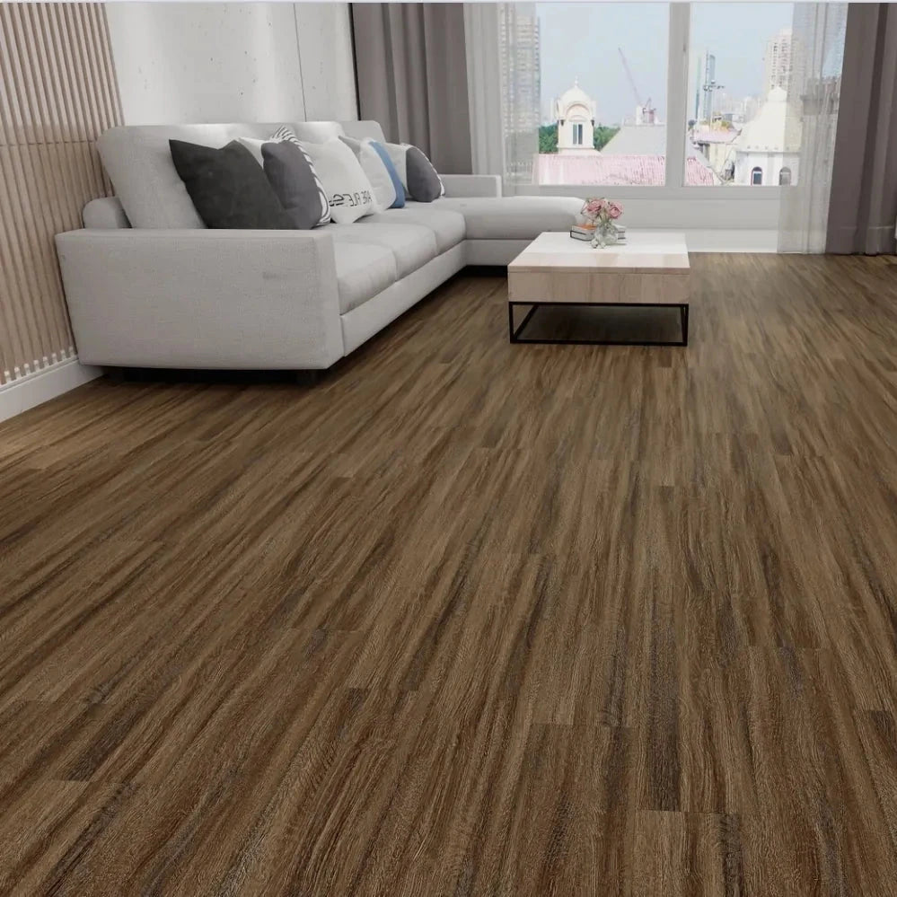 Brown wood-look laminate or vinyl flooring shown installed in a modern living room with a white sectional sofa, coffee table, and large windows.